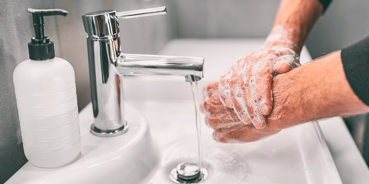 hombre lavándose las manos en casa